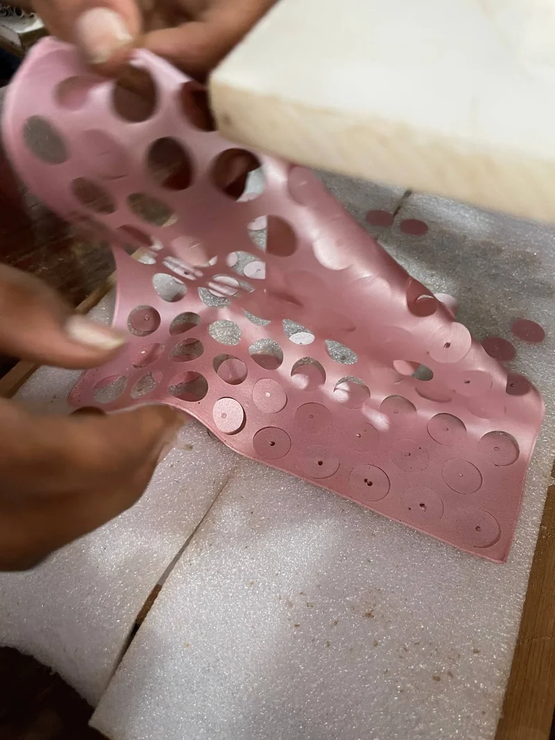 Pink film after cutting, lifted by hand