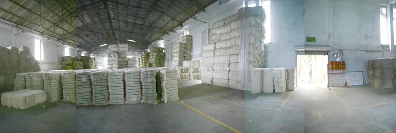 Panoramic factory view of stacked cotton bales beneath a steel roof, from Botto's 2010 Welspun project